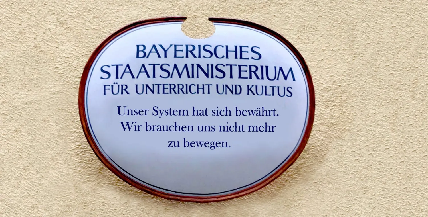 Schild am Kultusministerium: „Unser System hat sich bewährt. Wir brauchen uns nicht mehr zu bewegen.“